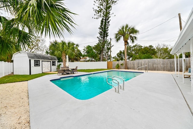 view of swimming pool with a fenced backyard, a fenced in pool, an outbuilding, and a patio