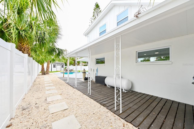 deck with a storage unit, a fenced backyard, and an outdoor structure