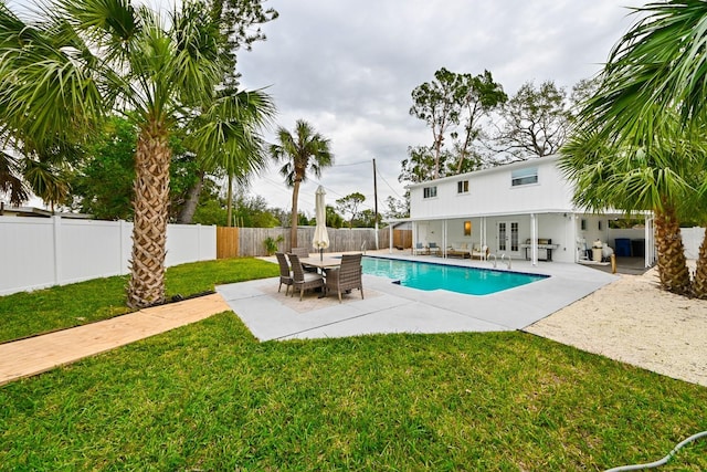 view of pool featuring a fenced in pool, a lawn, french doors, a fenced backyard, and a patio area