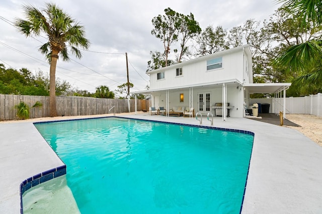 view of swimming pool with a patio, french doors, a fenced in pool, and a fenced backyard