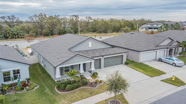 view of front of house featuring a garage, a front lawn, and covered porch