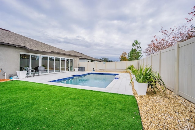 view of swimming pool featuring a patio area and a yard