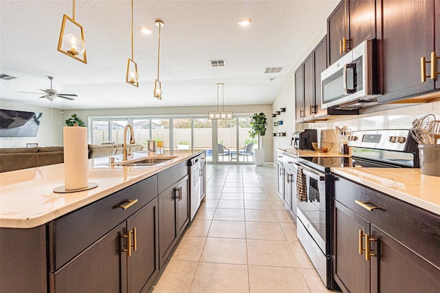 kitchen with pendant lighting, sink, a textured ceiling, and appliances with stainless steel finishes