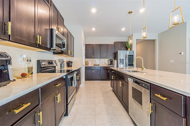 kitchen with sink, dark brown cabinetry, hanging light fixtures, appliances with stainless steel finishes, and light tile patterned floors