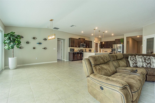 tiled living room with lofted ceiling and an inviting chandelier