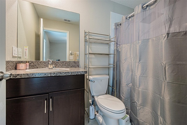 bathroom featuring toilet, vanity, a shower with shower curtain, and a textured ceiling