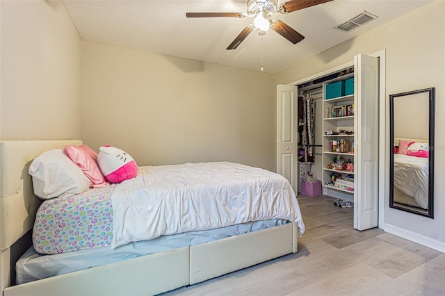 bedroom featuring ceiling fan, a closet, and light hardwood / wood-style flooring