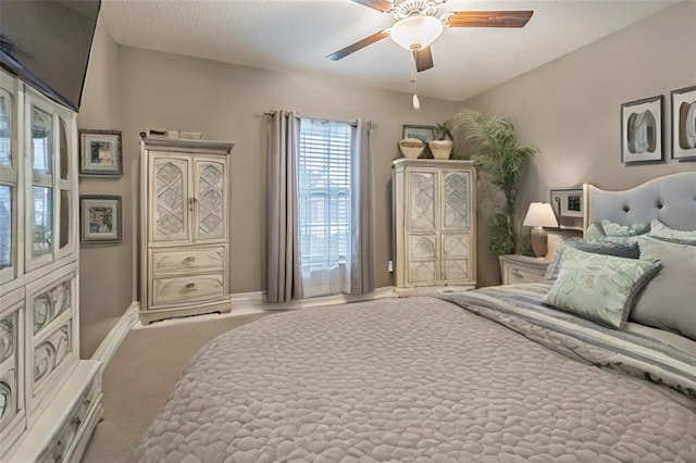 carpeted bedroom with ceiling fan and a textured ceiling