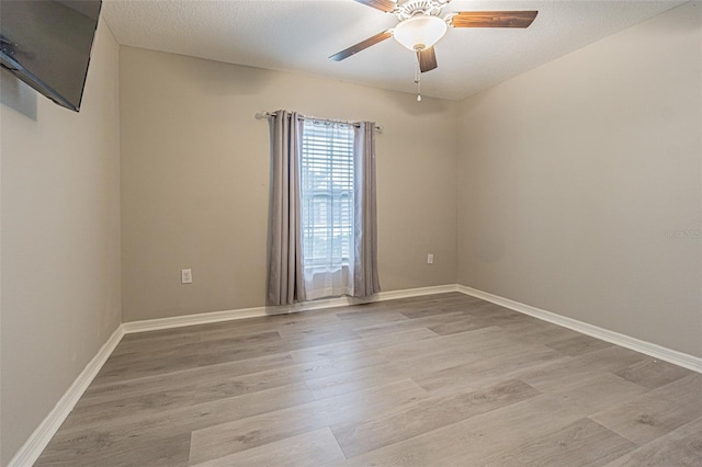 empty room featuring ceiling fan, a textured ceiling, and light hardwood / wood-style flooring