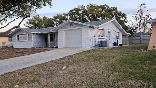 ranch-style house with a front lawn, central AC unit, and a garage