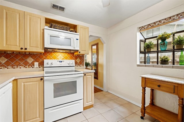 kitchen featuring light tile patterned flooring, light brown cabinetry, decorative backsplash, and white appliances