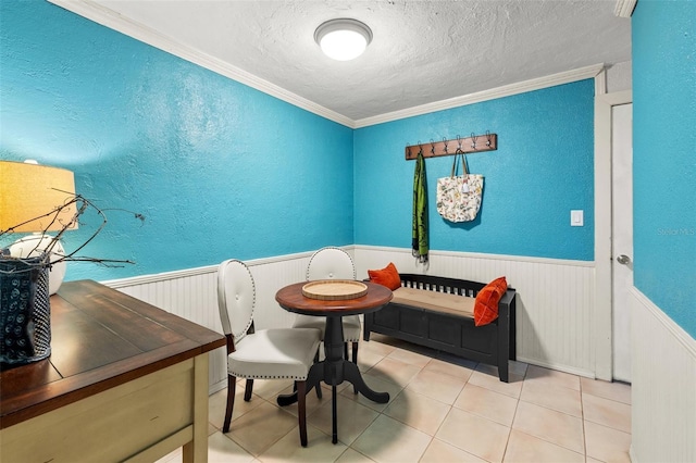 dining space featuring tile patterned flooring, ornamental molding, and a textured ceiling