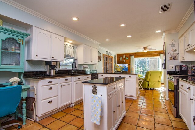 kitchen featuring white cabinetry, a healthy amount of sunlight, stainless steel electric range oven, and kitchen peninsula