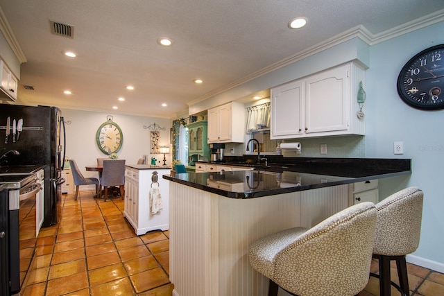 kitchen with kitchen peninsula, crown molding, white cabinetry, stainless steel range with electric cooktop, and a breakfast bar area