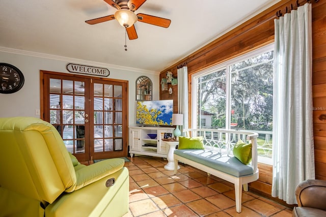 living area featuring ceiling fan, light tile patterned floors, ornamental molding, and french doors