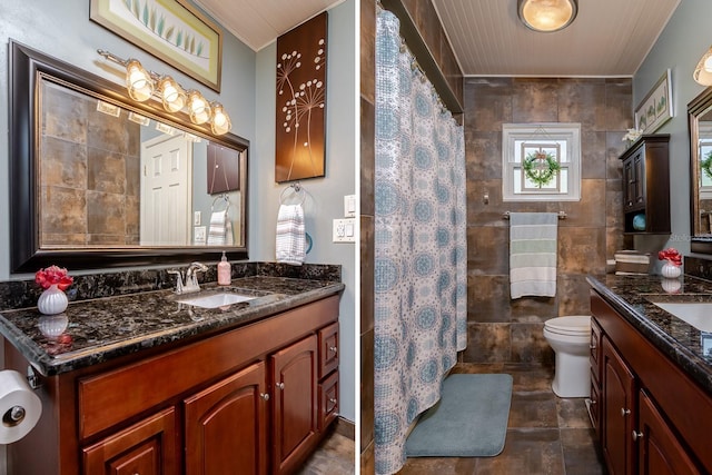 bathroom featuring walk in shower, vanity, tile walls, and toilet