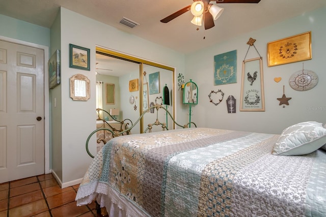 tiled bedroom featuring ceiling fan and a closet