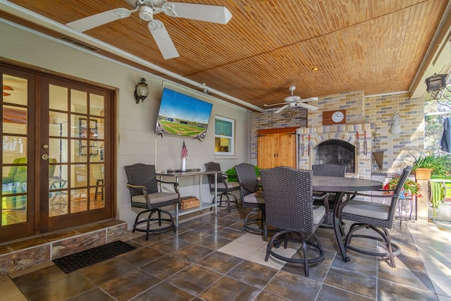 view of patio / terrace with ceiling fan, french doors, and an outdoor brick fireplace