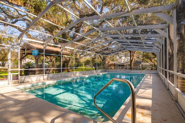 view of swimming pool featuring glass enclosure