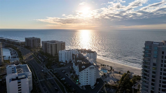 aerial view at dusk with a view of the beach and a water view