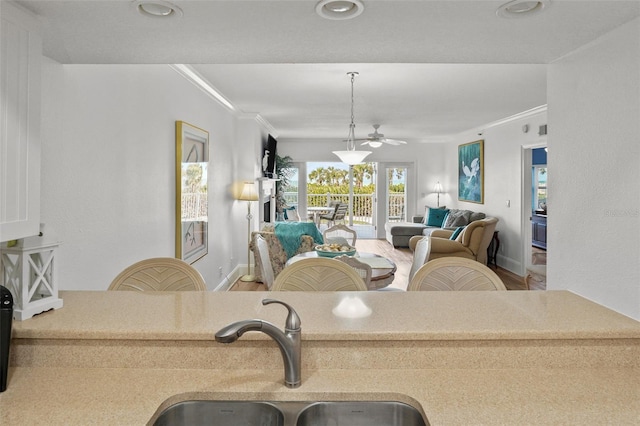 living room with ornamental molding, sink, and hardwood / wood-style floors