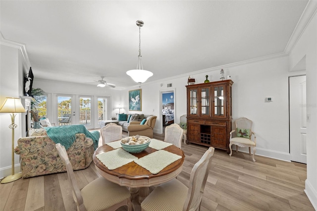 dining space with light hardwood / wood-style flooring, ornamental molding, and french doors