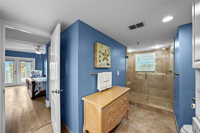 bathroom featuring walk in shower, toilet, french doors, and a textured ceiling