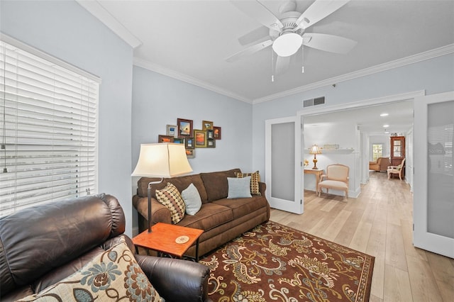 living room featuring crown molding, ceiling fan, light wood-type flooring, and french doors