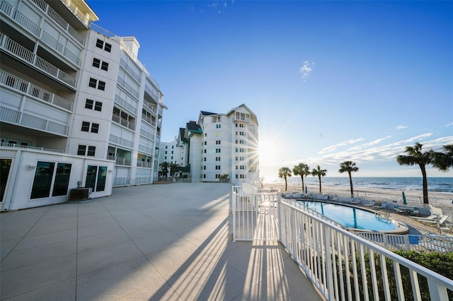 balcony featuring central AC unit, a patio area, and a water view