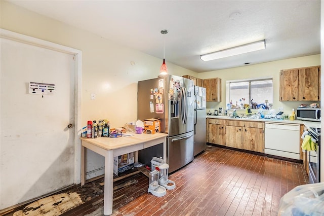 kitchen with hanging light fixtures, dark hardwood / wood-style flooring, and stainless steel appliances