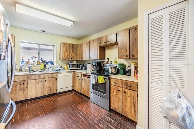 kitchen featuring appliances with stainless steel finishes and dark hardwood / wood-style floors