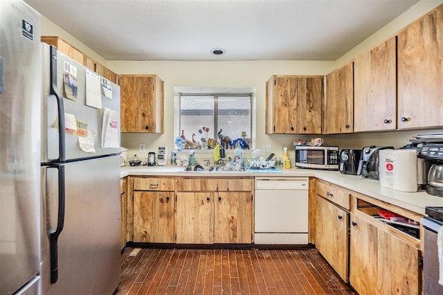 kitchen featuring dark wood-type flooring, appliances with stainless steel finishes, and sink