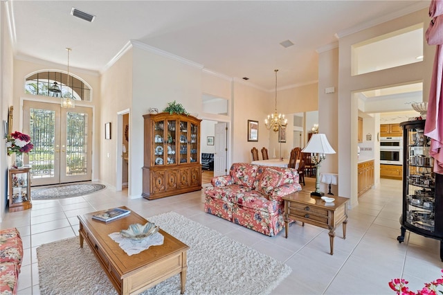 tiled living room with an inviting chandelier, crown molding, french doors, and a high ceiling