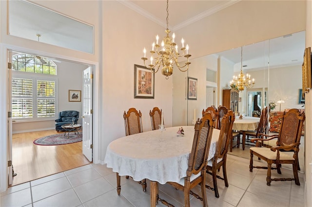 tiled dining room featuring crown molding and a chandelier