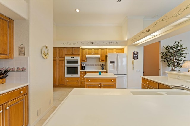 kitchen with tasteful backsplash, white appliances, ornamental molding, and light tile patterned flooring