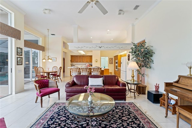 living room with crown molding, ceiling fan with notable chandelier, and light tile patterned flooring