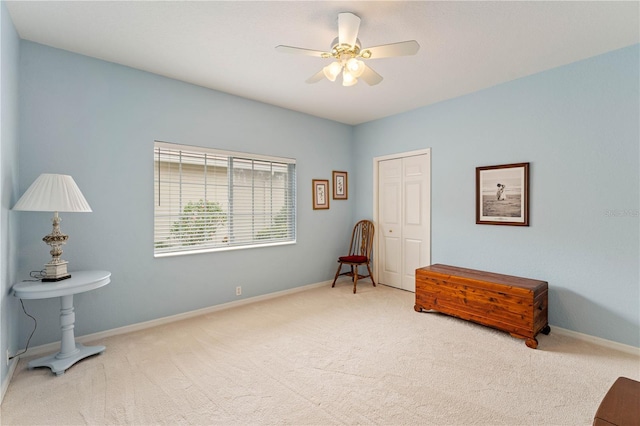 sitting room with ceiling fan and carpet flooring