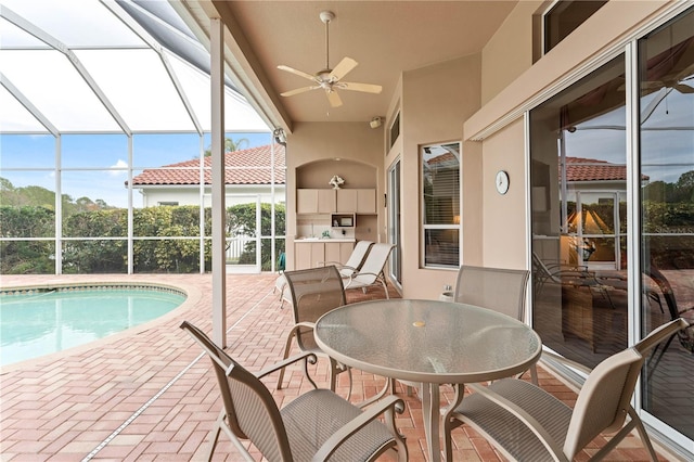 view of swimming pool featuring ceiling fan, glass enclosure, and a patio area