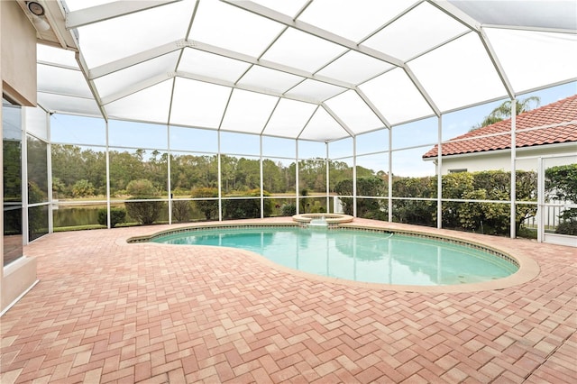 view of pool with a patio area, an in ground hot tub, and glass enclosure