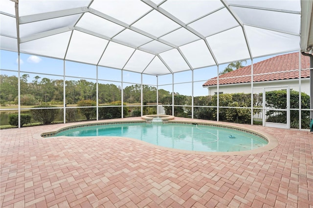 view of pool with an in ground hot tub, a patio area, and glass enclosure