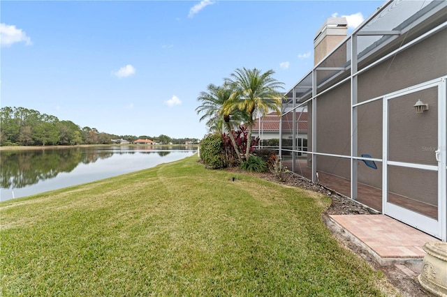 view of yard with a lanai and a water view