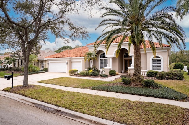 mediterranean / spanish home with a garage and a front yard