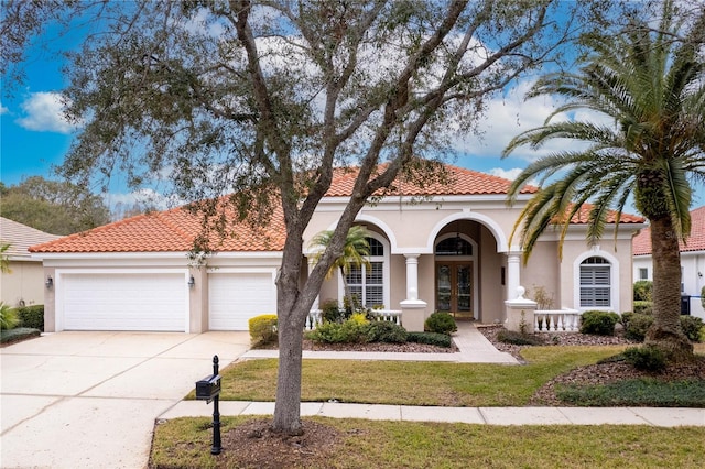 mediterranean / spanish-style home with french doors and a garage