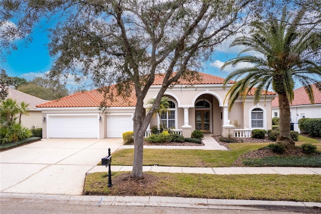 mediterranean / spanish-style house with a garage, a front lawn, and french doors