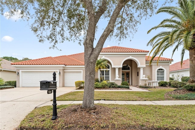 mediterranean / spanish house with a garage and a front lawn