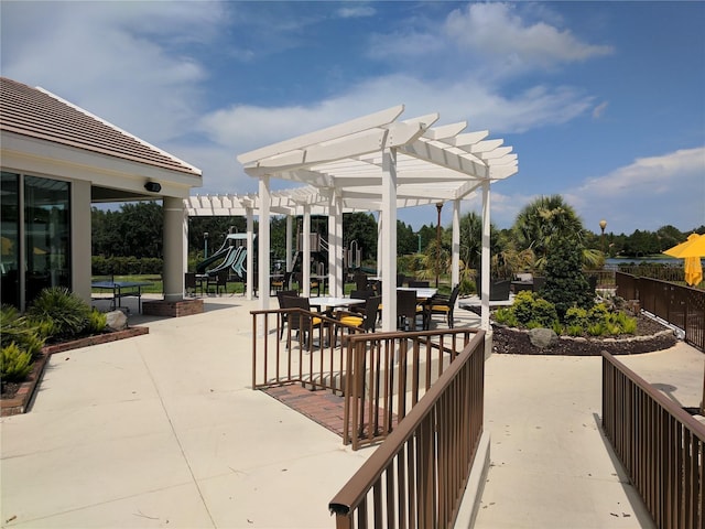 view of patio featuring a playground and a pergola