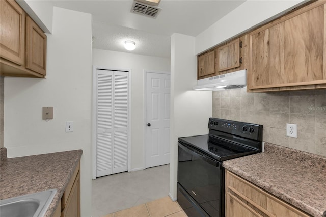 kitchen featuring sink, backsplash, light tile patterned floors, and black electric range oven