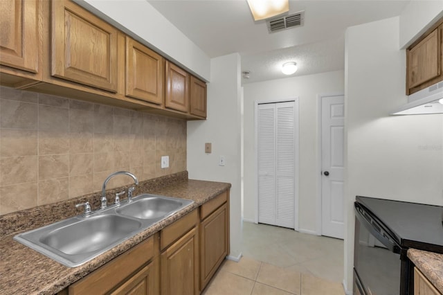 kitchen with light tile patterned floors, backsplash, and sink