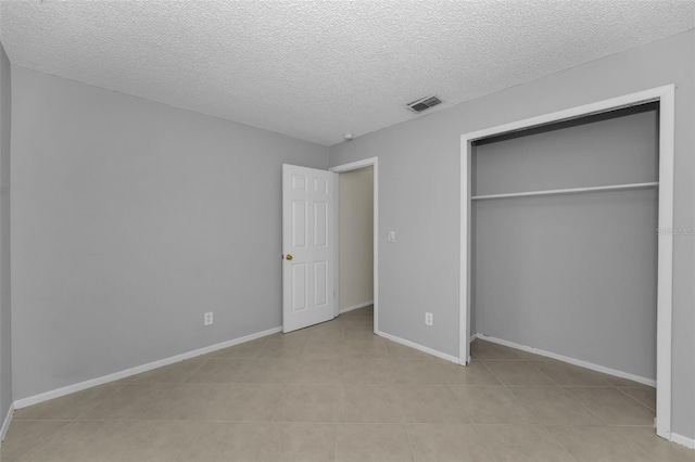 unfurnished bedroom featuring a textured ceiling and a closet