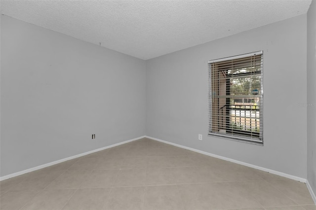 unfurnished room featuring a textured ceiling and light tile patterned floors